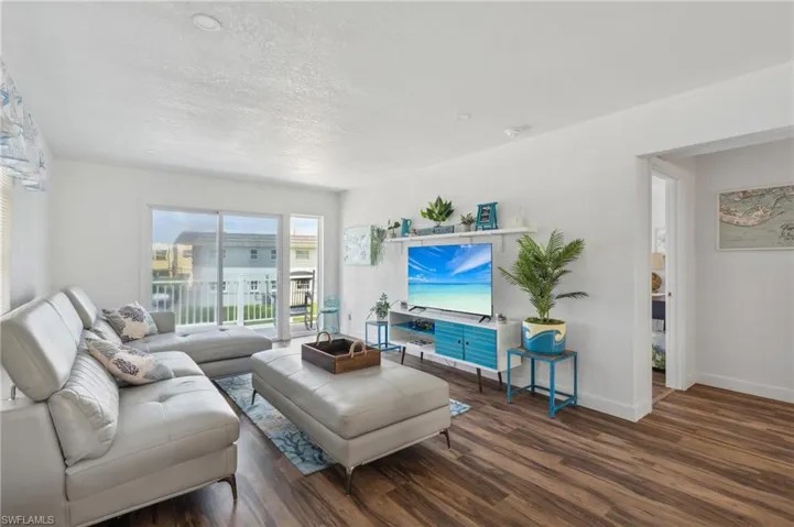 Living room with a textured ceiling and dark hardwood / wood-style floors