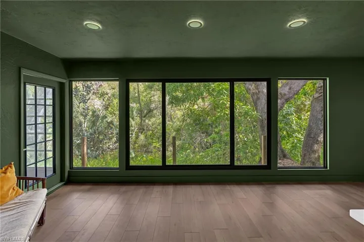 Family room features large picture windows overlooking the tranquil nature oasis and can be enjoyed from the living, dining and kitchen.