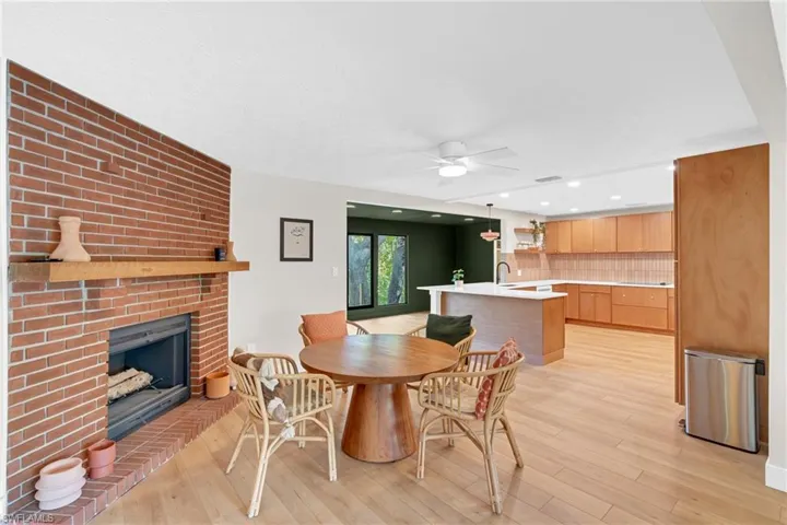 Dining area opens to the kitchen with original brick fireplace and wood mantel as the main focal point in this space.