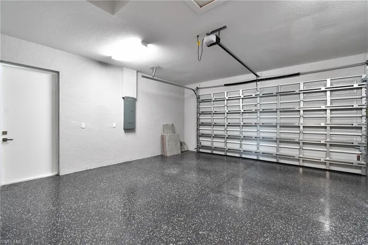 Garage featuring a garage door opener and electric panel
