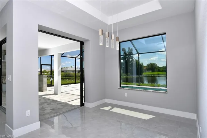 Tiled empty room with a water view and a tray ceiling