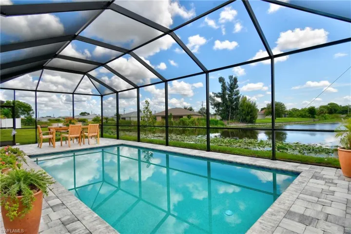 View of swimming pool featuring a water view, a patio area, and a lanai