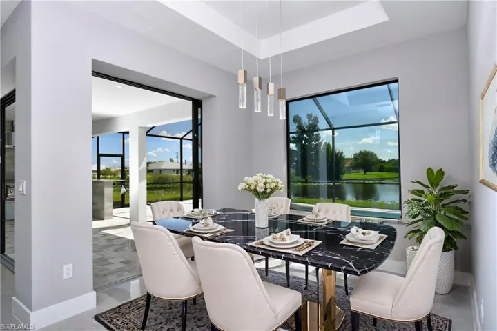 Tiled dining area with a water view and a raised ceiling