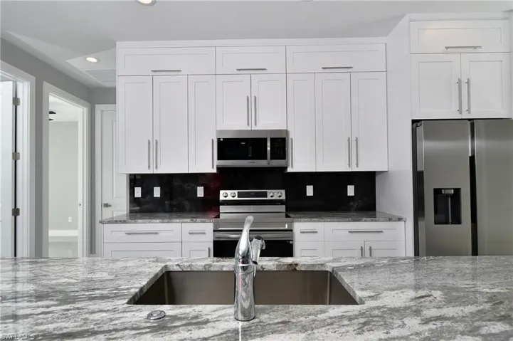 Kitchen featuring white cabinets and appliances with stainless steel finishes
