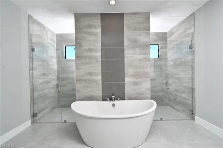 Bathroom featuring tile patterned flooring, tile walls, and independent shower and bath