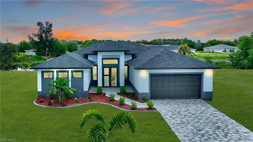 View of front of home featuring a garage and a yard