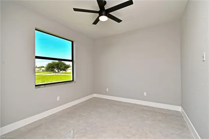 Unfurnished room with ceiling fan and light tile patterned floors