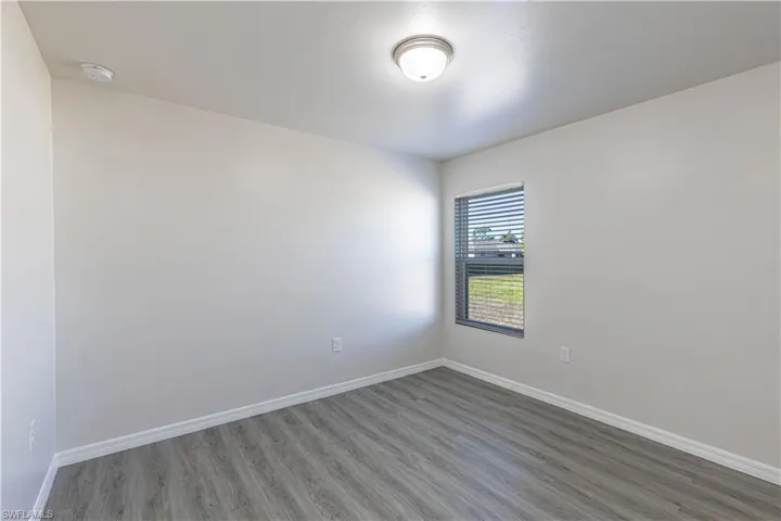 Unfurnished room featuring wood finished floors and baseboards