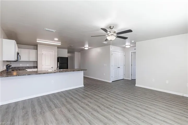 Unfurnished living room with light wood-style flooring and ceiling fan
