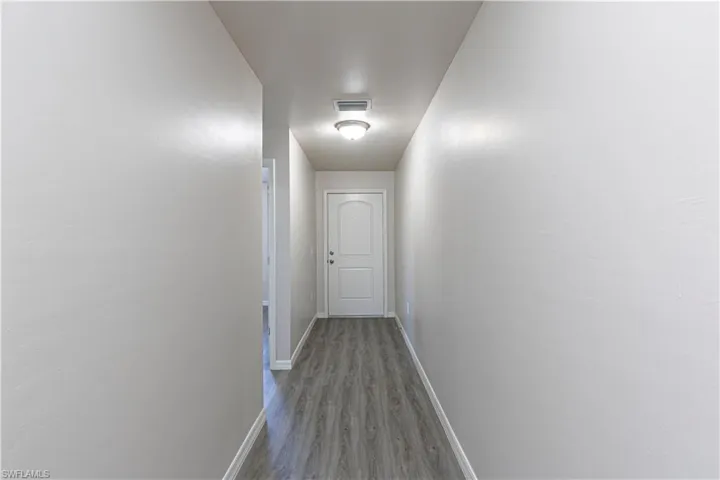 Hall with baseboards and wood finished floors