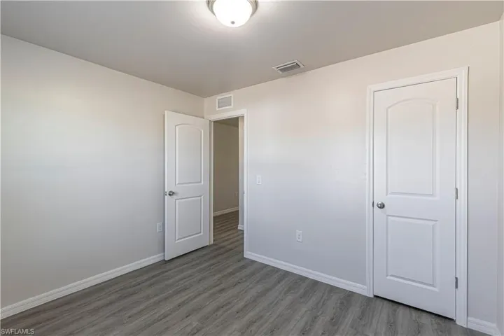 Unfurnished bedroom with baseboards and wood finished floors