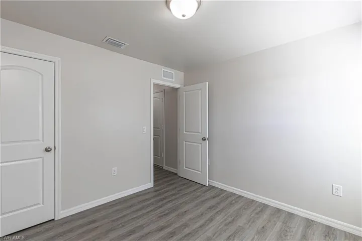 Unfurnished bedroom with baseboards and wood finished floors
