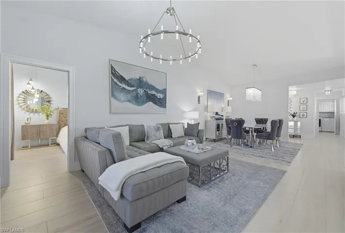 Living room with lofted ceiling, a chandelier, and washer / clothes dryer