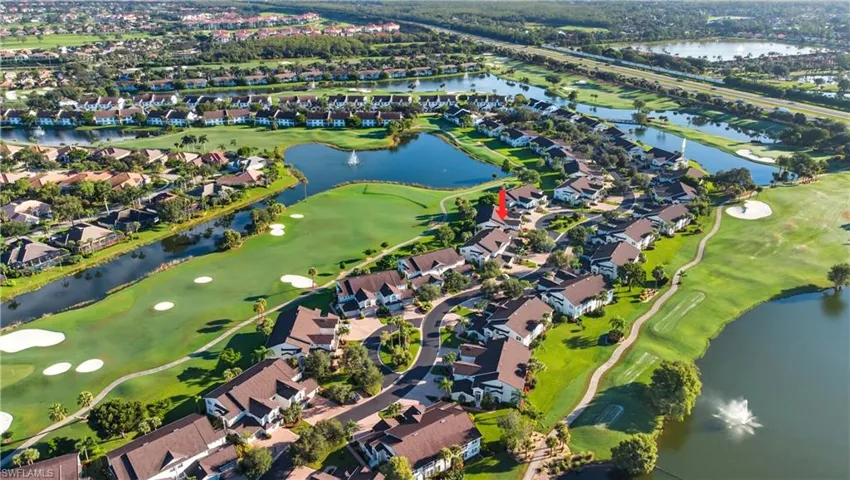 Aerial view of property's location featuring a nearby body of water, nearby suburban area, and a golf course