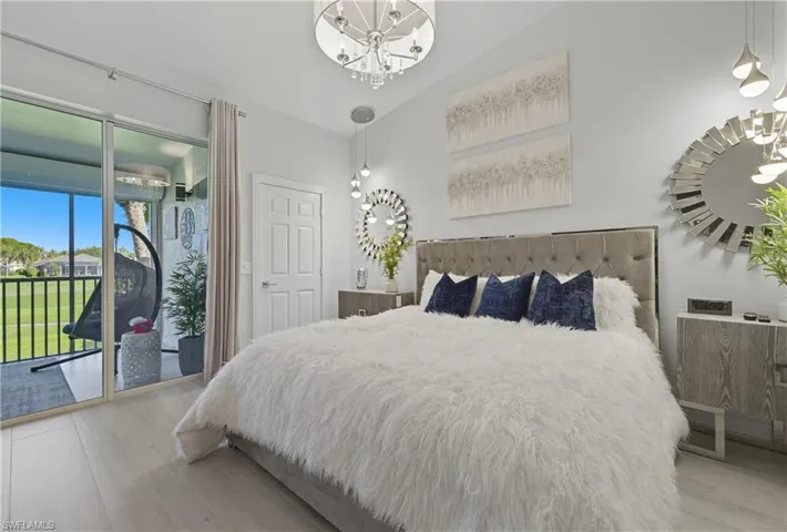 Bedroom featuring access to exterior, a chandelier, and light wood finished floors