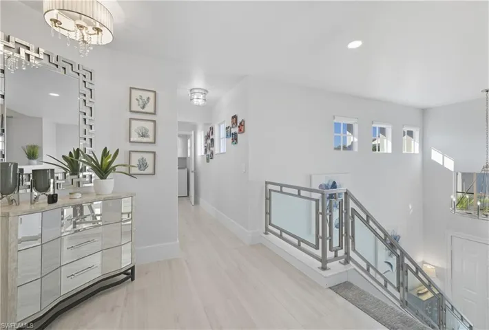 Corridor with a chandelier, an upstairs landing, recessed lighting, and light wood finished floors