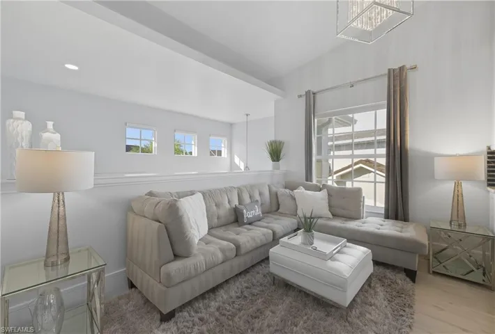Living room with a chandelier, wood finished floors, and recessed lighting
