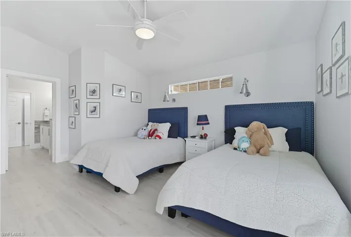 Bedroom with light wood-type flooring, a ceiling fan, and vaulted ceiling