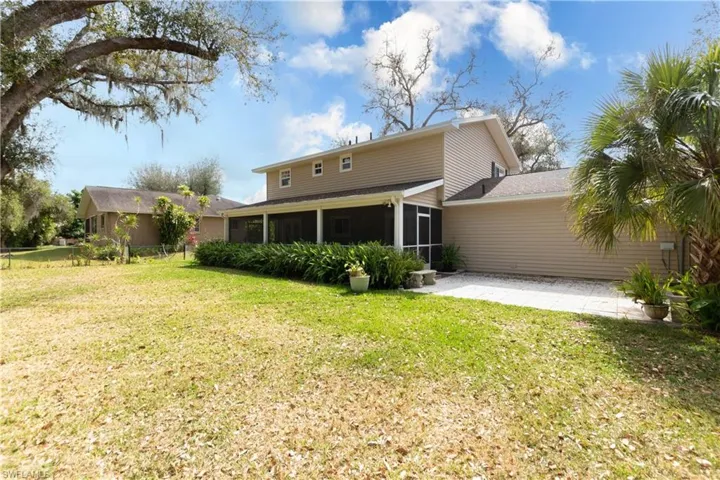 Back of property with a patio and a sunroom
