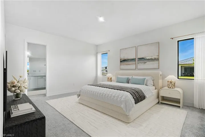 Bedroom with light carpet and connected bathroom