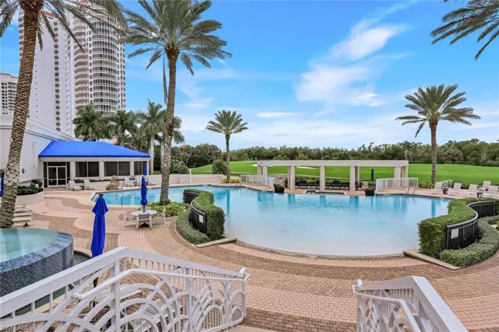 Community pool featuring a patio, a jacuzzi, a sunroom, and view of Bay Island Golf Course.