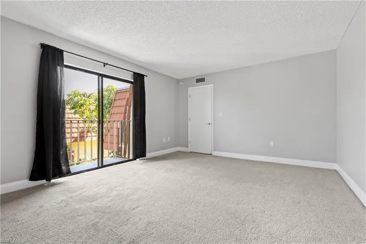 Empty room featuring carpet and a textured ceiling