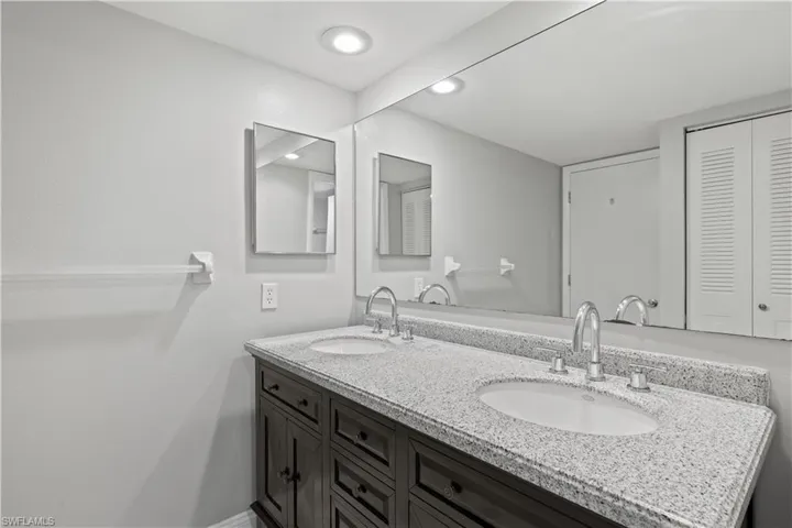 Bathroom featuring double vanity and a closet