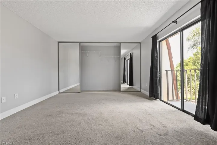 Unfurnished bedroom featuring carpet flooring, access to outside, a closet, and a textured ceiling