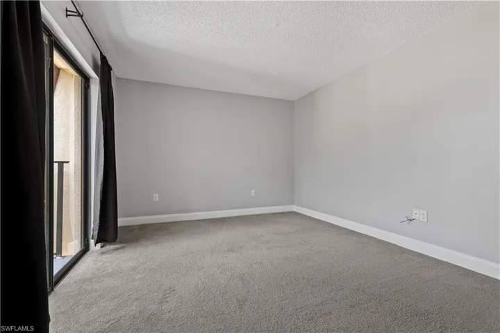 Spare room featuring light colored carpet and a textured ceiling