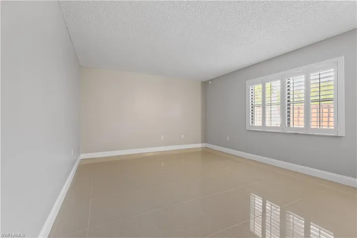 Unfurnished room featuring light tile patterned flooring and a textured ceiling