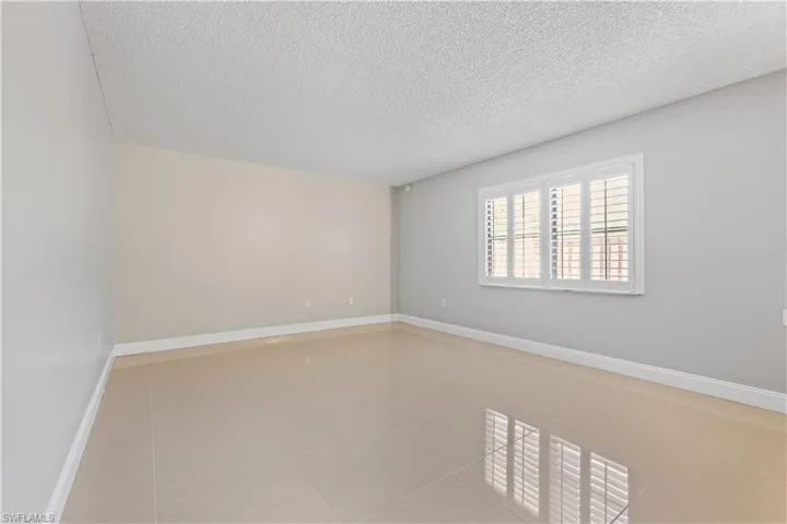 Empty room featuring a textured ceiling and light tile patterned flooring