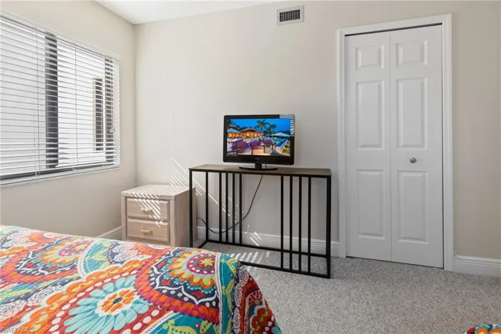 Carpeted bedroom featuring a closet