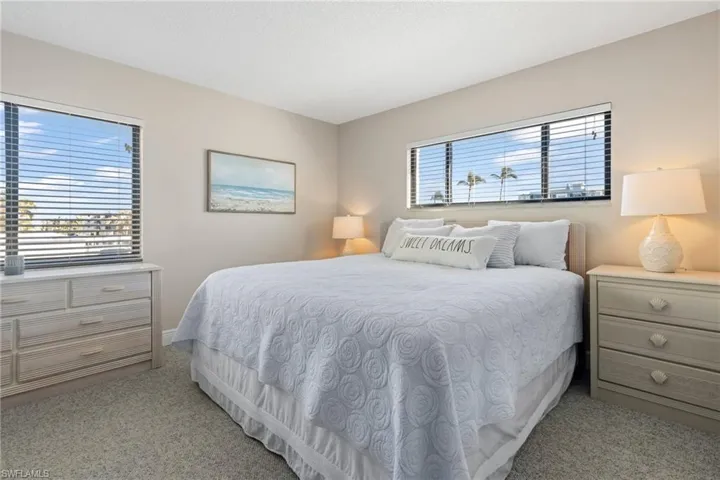 Carpeted bedroom featuring multiple windows