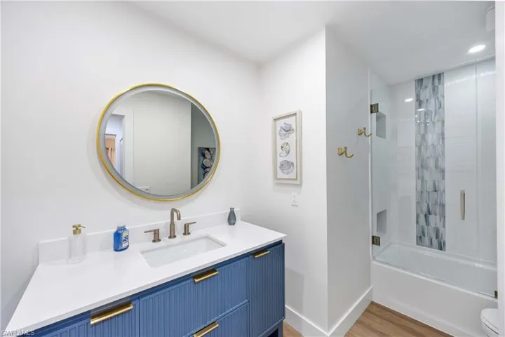 Full bathroom featuring vanity, toilet, shower / bath combination, and hardwood / wood-style floors