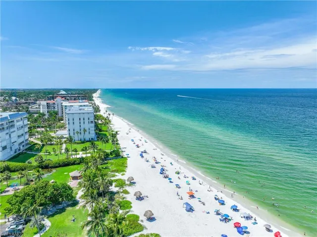 Birds eye view of property featuring a water view and a beach view