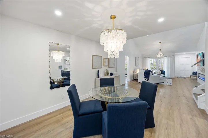 Dining room featuring lofted ceiling, an inviting chandelier, and light hardwood / wood-style flooring