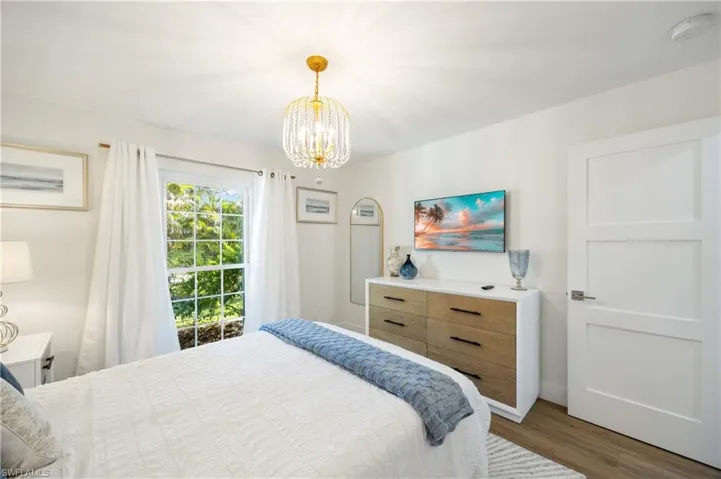 Bedroom featuring dark hardwood / wood-style flooring and a chandelier