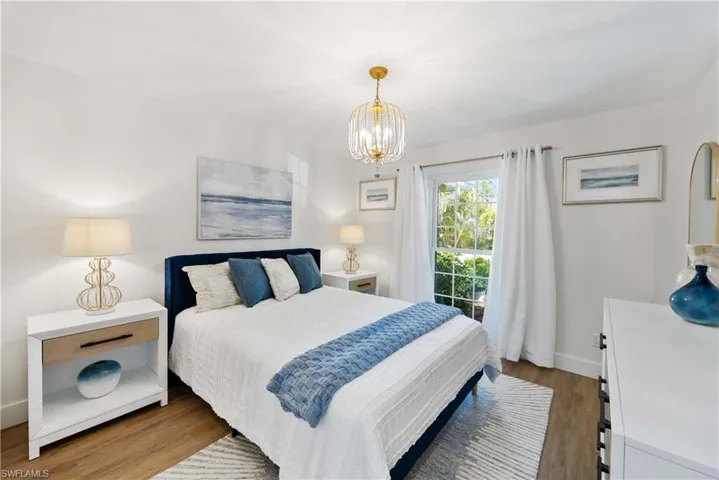 Bedroom featuring hardwood / wood-style floors and a chandelier