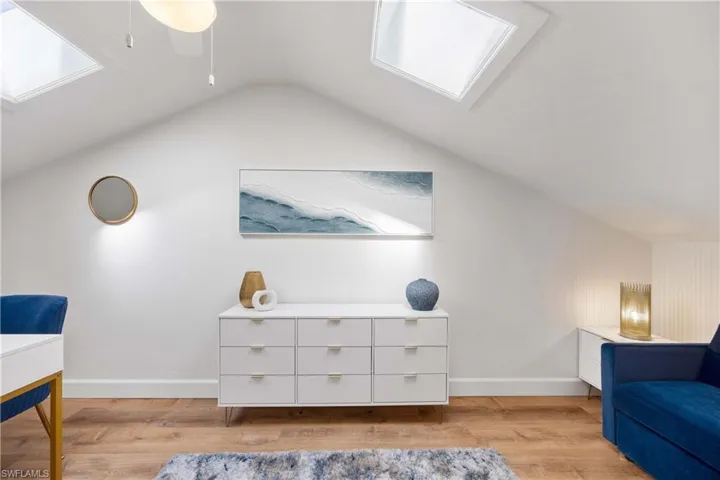 Sitting room featuring light hardwood / wood-style flooring and lofted ceiling with skylight