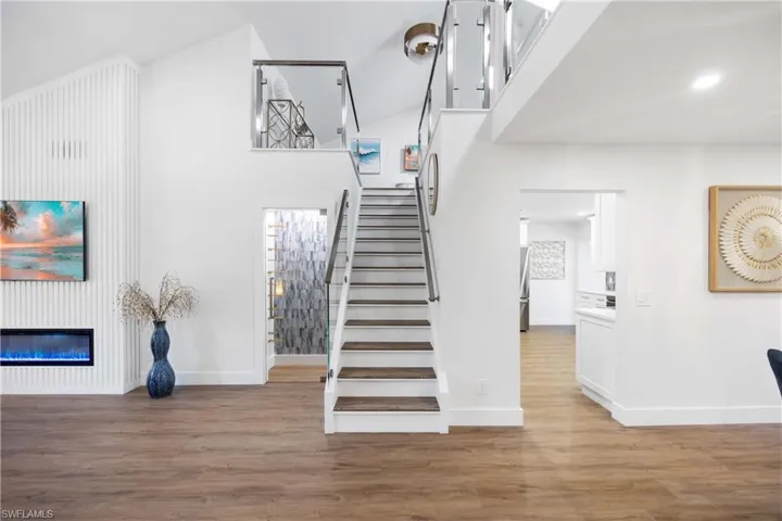 Staircase featuring a towering ceiling and wood-type flooring