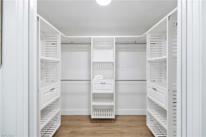 Walk in closet with light wood-type flooring