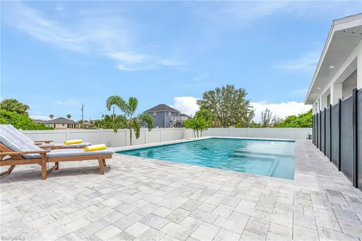 View of swimming pool featuring patio surround and a fenced backyard
