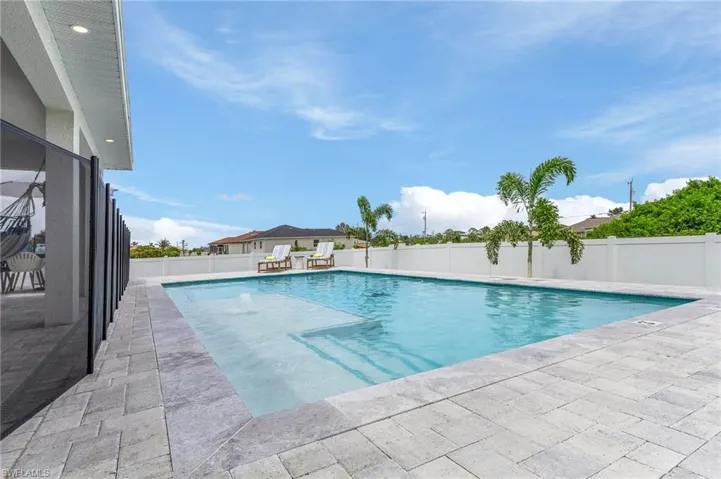 View of swimming pool with patio surround and a fenced backyard