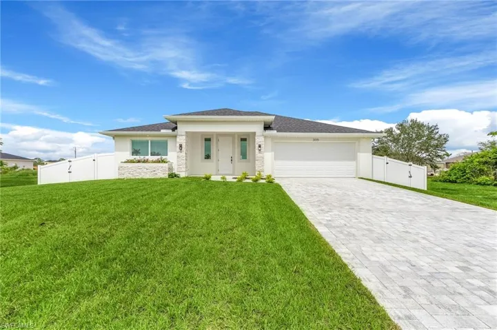 Prairie-style house with a gate, an attached garage, decorative driveway, and stucco siding