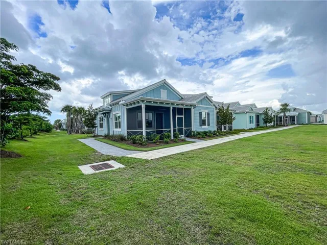 View of front facade featuring a sunroom and a front lawn