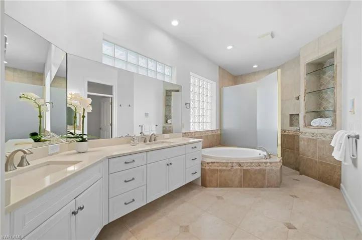 Bathroom with tile patterned floors, vanity, and plus walk in shower
