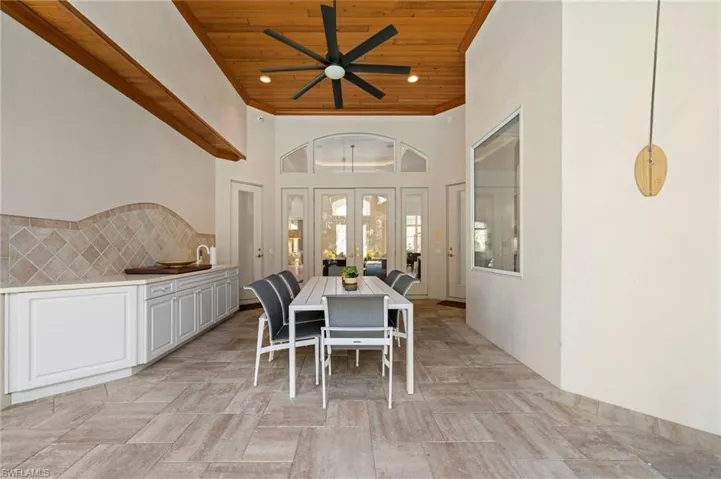 Dining room with ceiling fan, a towering ceiling, french doors, and wooden ceiling