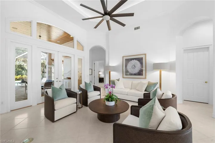Living room featuring high vaulted ceiling, french doors, crown molding, ceiling fan, and light tile patterned flooring