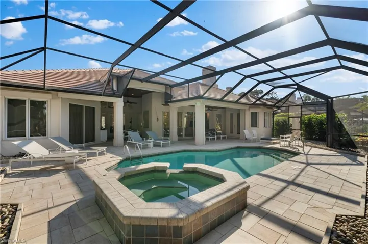 View of pool featuring ceiling fan, a lanai, an in ground hot tub, and a patio