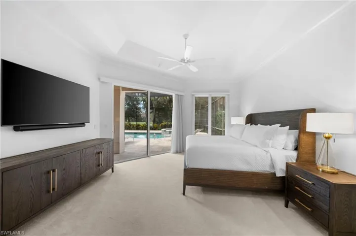 Main Bedroom with access to exterior, light carpet, ornamental molding, a raised ceiling, and ceiling fan